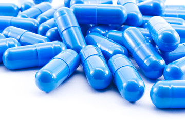 Blue capsules pill on white background. Antibiotics drug resistance.