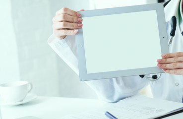 Female medicine doctor shows tablet computer with white screen close-up. Contact information exchange, introducing gesture at formal meeting concept