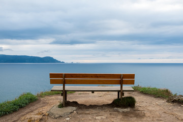 Naklejka na ściany i meble Lonely bench, overlooking the cliffs