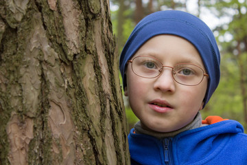 a boy near a pine tree,The boy hugged a tree in the forest, protecting the nature of the forest