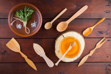 Wooden cutlery, top view. Cutlery, rosemary and honey on wooden boards. Eco concept with natural...