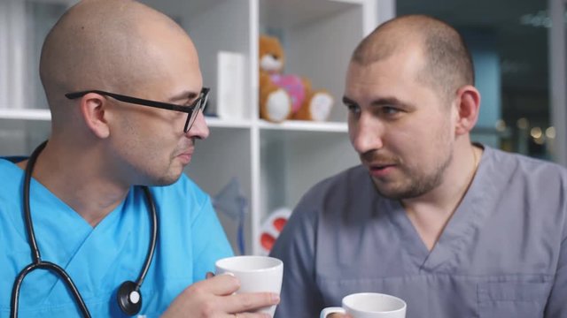 Two men doctors relieve stress alcohol in the doctor's lounge after a hard working day.
