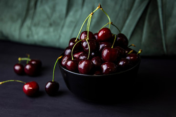 cherries in black containers on the table