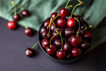 cherries in black containers on the table