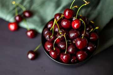 cherries in black containers on the table