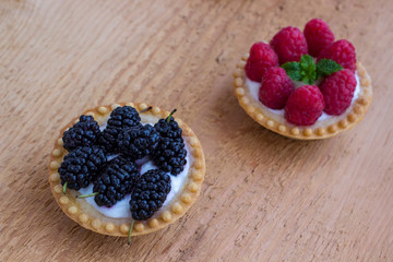 Basket-shaped cookies with raspberry, blueberry  berries. Wooden background