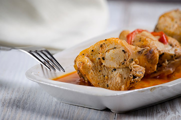 Chakhokhbili, traditional Georgian dish of stewed chicken, tomato and pepper with fresh herbs on wooden background, closeup