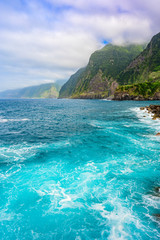 Fototapeta premium Beautiful wild coast scenery view with Bridal Veil Falls (Veu da noiva) at Ponta do Poiso in Madeira Island. Near Porto Moniz, View from Seixal, Portugal.