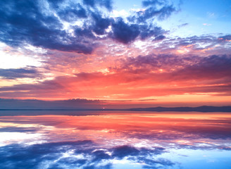 Fototapeta premium Amazing sunset and sky reflection in the water.