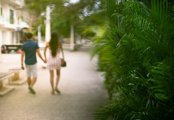 Fototapeta na wymiar A couple in love holding hands walking along the street 