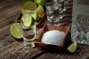 Tequila with  salt and lime on a old wooden background.