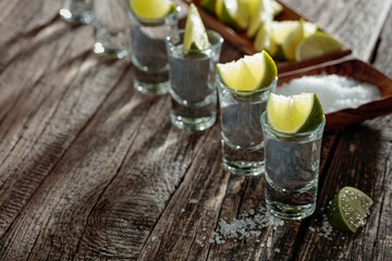 Tequila with  salt and lime on a old wooden background.