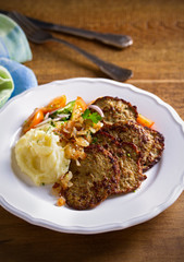 Chicken liver pancakes with mashed potato and vegetables on white plate. Liver side dish