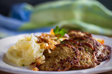 Chicken liver pancakes with mashed potato and vegetables on white plate. Liver side dish