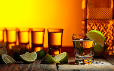Tequila with  salt and lime on a old wooden background.