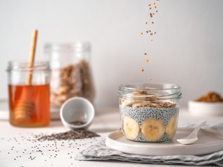 Healthy breakfast concept and idea - chia pudding with organic banana and oatmeal granola.Glass jar...