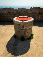 a fountain out of stone with a red lid