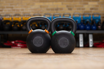 Closeup Two Black, Orange, and Green Kettle Bells