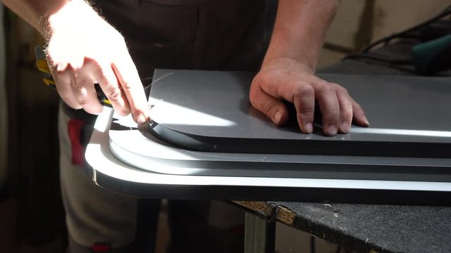 Male carpenter working on the production of furniture. Cut the pvc hem on both sides of the rounded parts