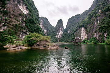 Fototapeta na wymiar Boat cave tour in Trang An Scenic Landscape formed by karst towers and plants along the river (UNESCO World Heritage Site). It's Halong Bay on land of Vietnam. Ninh Binh province, Vietnam.