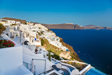 View of traditional white houses and churches with blue domes over the Caldera in Oia town on Santorini island