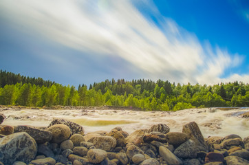 Beautiful waterscape with white moving cloud and waterfall from uphill in majestic outdoor in northern europe