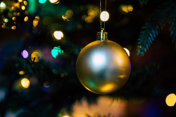 Golden decoration globe on christmas tree close up