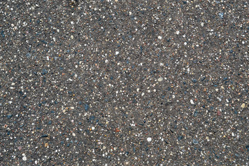The texture of the background of stone black gray asphalt road with small pebbles