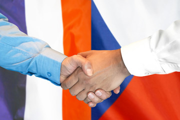 handshake on France and Czech Republic flag background.