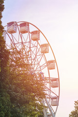 Ferris wheel carousel over sky with a sunlight
