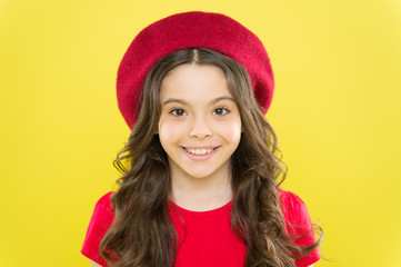 A smile on her lips. Smiling kid with white healthy smile on beautiful face. Adorable little girl with big smile on yellow background. Cute small child with long wavy hair and happy smile