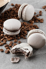 Fototapeta na wymiar French macaroons isolated with coffee beans. Selective focus. macaroon in gray tone. French crash macarons on gray stone background. Stylish arrangement sweet. Flat lay, top view.