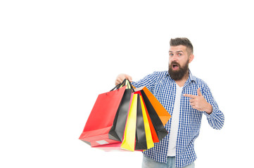 Dont miss the sale. Bearded man pointing finger at shopping bags after seasonal sale isolated on white. Surprised hipster buying at sale price. Black Friday and cyber monday sale, copy space