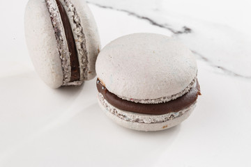 French macaroons isolated . Selective focus. macaroon in gray tone. Beautiful macaroons on marble background. Stylish arrangement sweet. Flat lay, top view.
