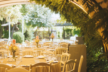 Outdoor wedding arrangements, tables, chairs at a restaurant. Green location.