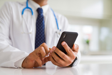 Close up middle age doctor man hands using smartphone