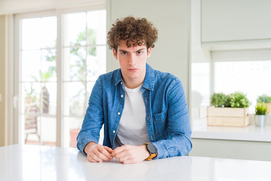 Young handsome man wearing casual denim jacket at home skeptic and nervous, frowning upset because of problem. Negative person.