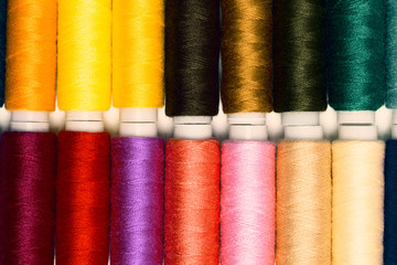 Close up colourful spools of thread. Macro photography fashion tailor background