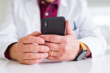 Close up of doctor hands using smartphone at the clinic