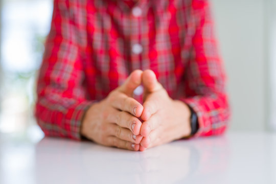 Close up of man hands with palms together over white table