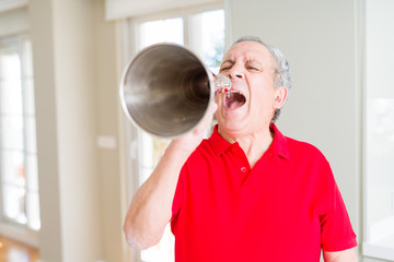 Senior man shouthing excited through vintage metal megaphone