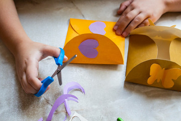 Crafts for children. The child makes a colorful paper craft. postcard. The child does crafts....