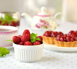 Raspberiies with mini tarts on a table
