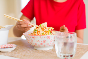 Close up of woman eating asian rice using chopsticks