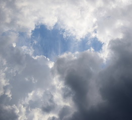 Obraz premium Der blaue Himmel bricht durch die dunkle Regenwolkendecke