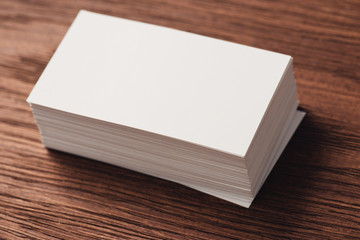 stack of white blank business cards on brown wooden surface