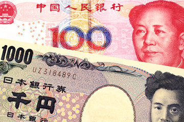 A one thousand Japanese yen bank note, close up in macro with a one hundred yuan Chinese renminbi bank note