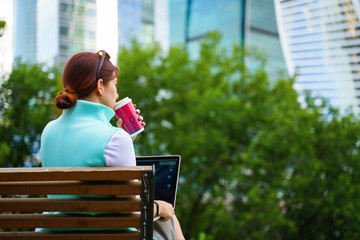 Fototapeta premium Portrait of business woman sitting with laptop and cup of coffee