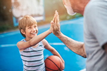 Grandfather and his grandson playing basketball.