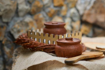 clay pot for honey on a wicker wooden table with a wooden spoon